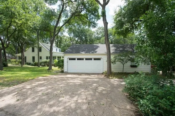 a view of a house with a yard and large tree