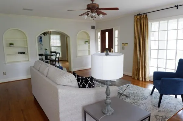 a living room with furniture two window and a dining table