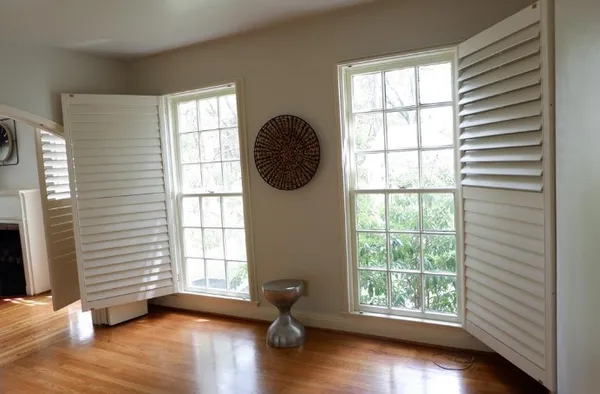 a view of an empty room with wooden floor and a window