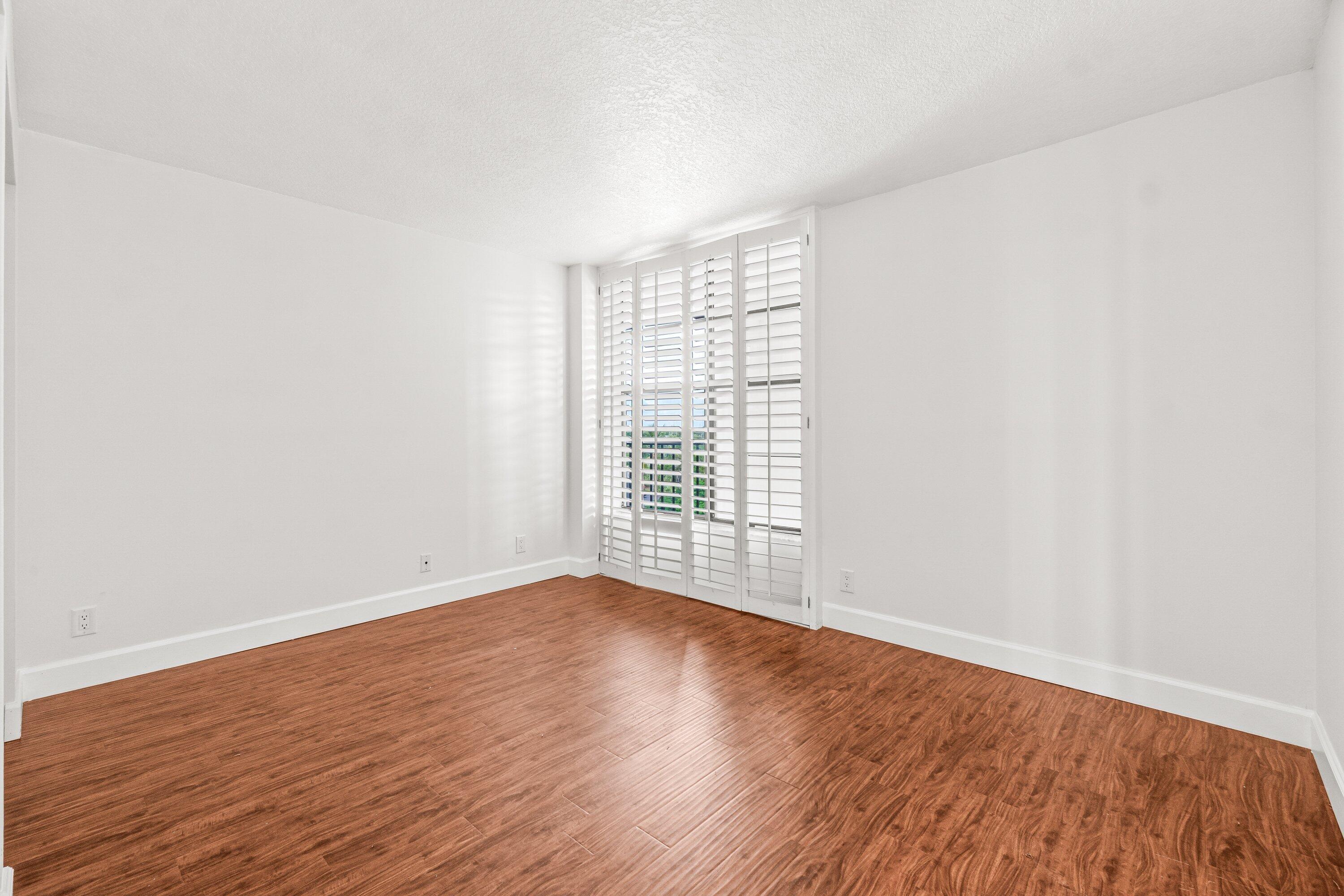 15 Royal Palm Way, Unit 604 Boca Raton, FL 33432 - Photo 16 of 41 a view of an empty room with wooden floor and a window