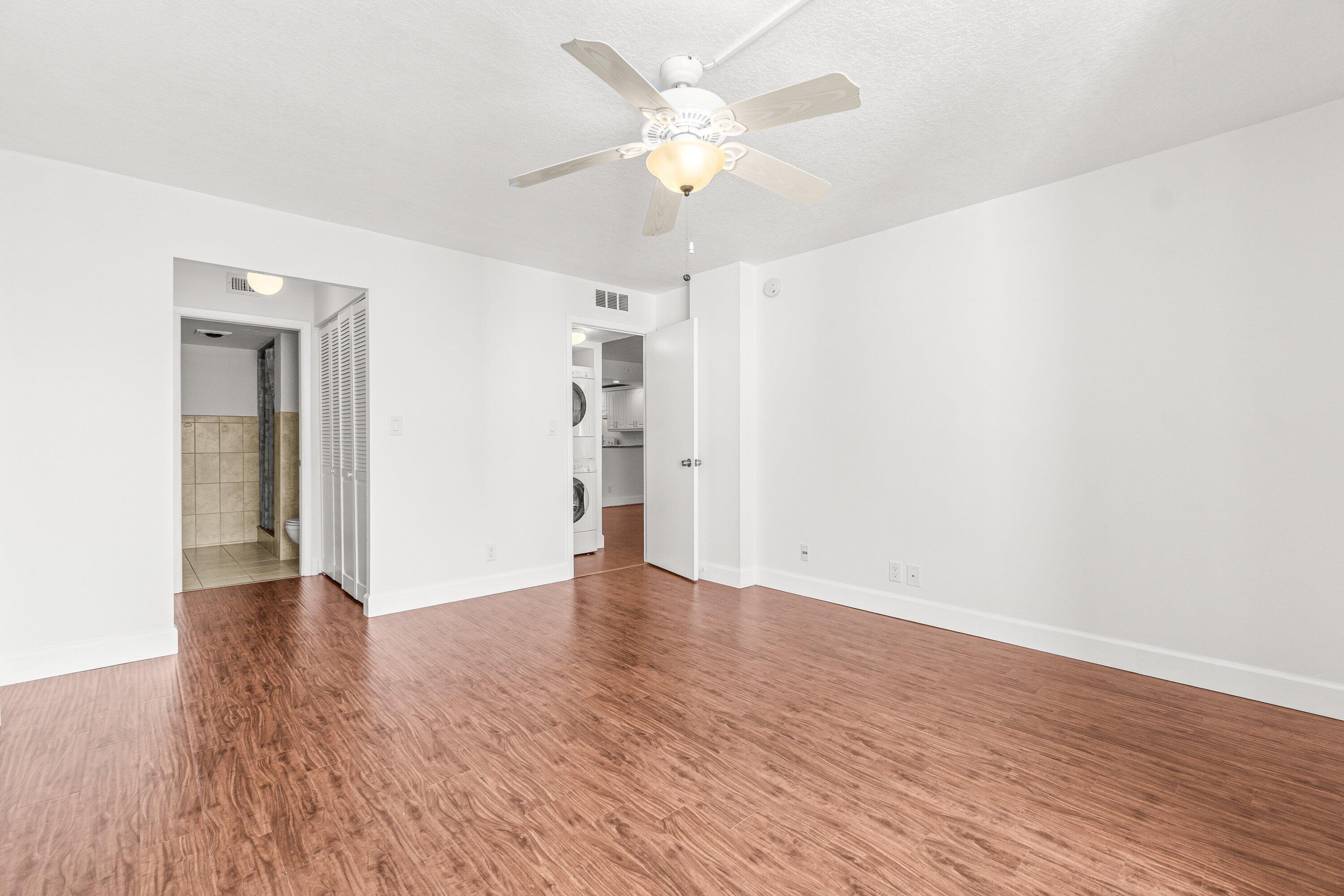 15 Royal Palm Way, Unit 604 Boca Raton, FL 33432 - Photo 21 of 41 an empty room with wooden floor and a ceiling fan