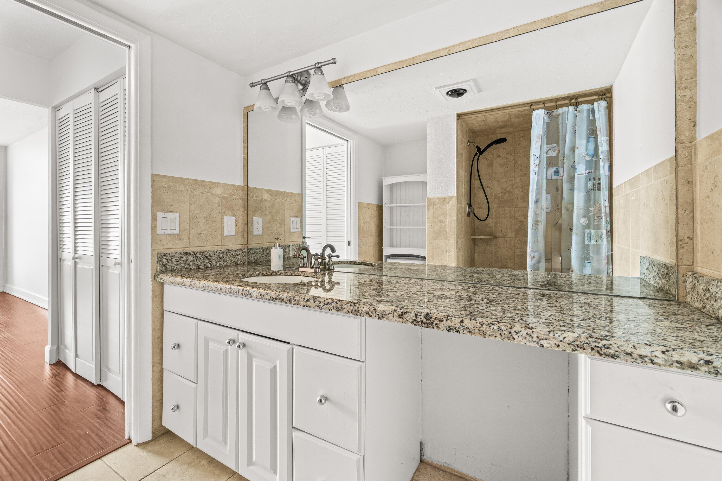 15 Royal Palm Way, Unit 604 Boca Raton, FL 33432 - Photo 23 of 41 a bathroom with a granite countertop sink and a mirror
