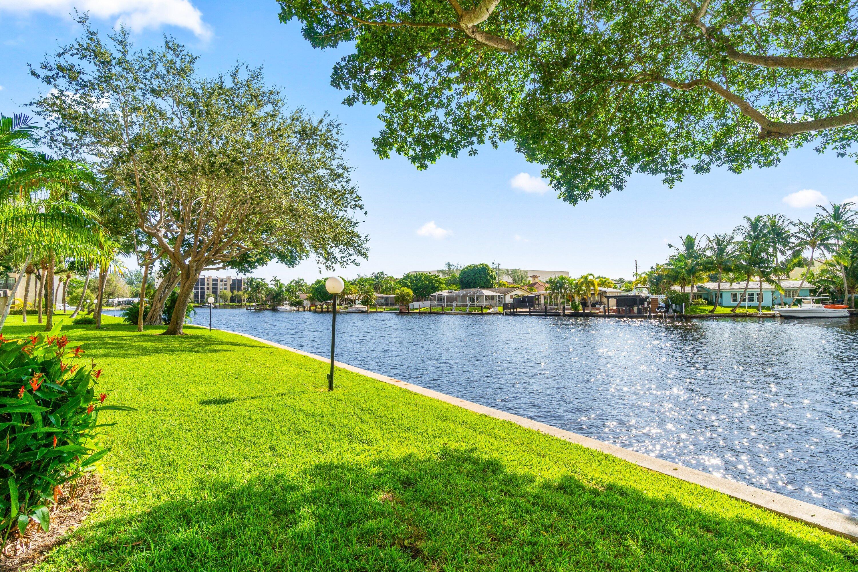 15 Royal Palm Way, Unit 604 Boca Raton, FL 33432 - Photo 34 of 41 a view of a lake with a yard and large trees