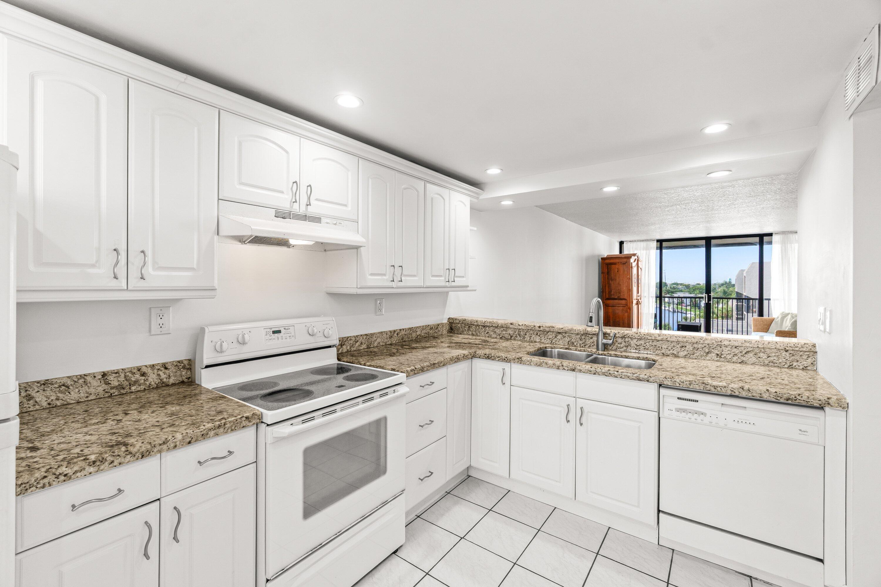 15 Royal Palm Way, Unit 604 Boca Raton, FL 33432 - Photo 6 of 41 a kitchen with granite countertop white cabinets and white appliances