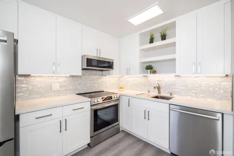 a kitchen with a refrigerator a stove a sink and a large window