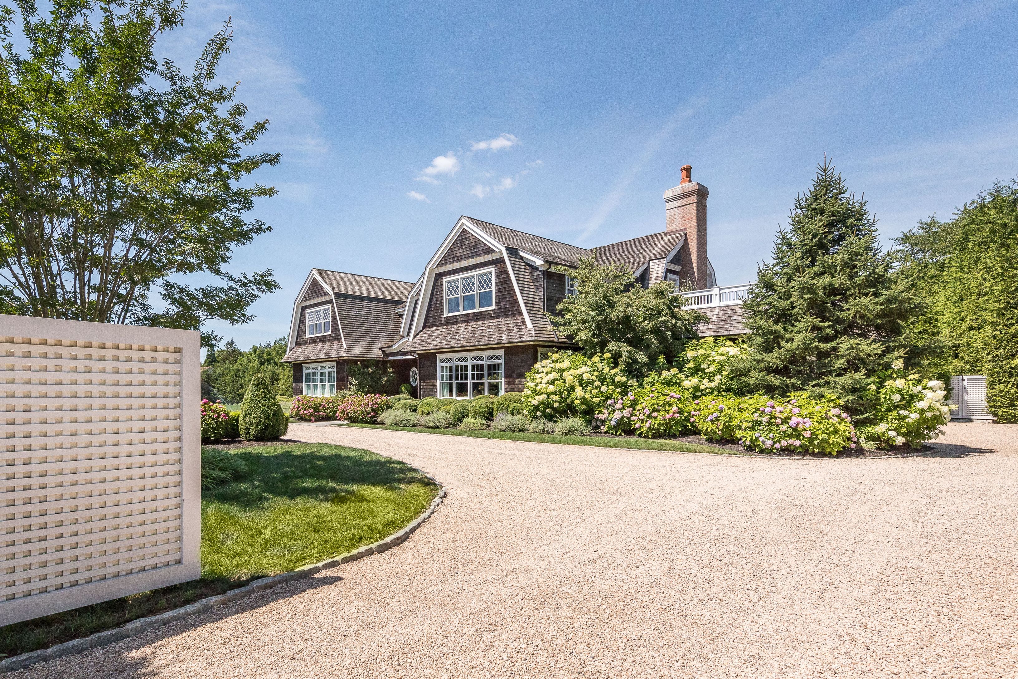 a front view of a house with a yard and potted plants