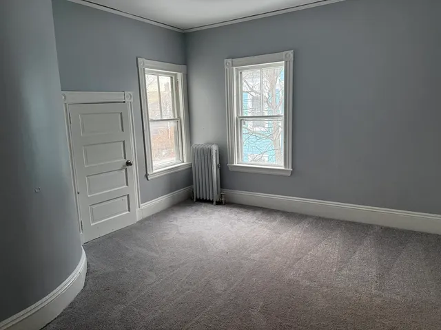 an empty room with windows and closet