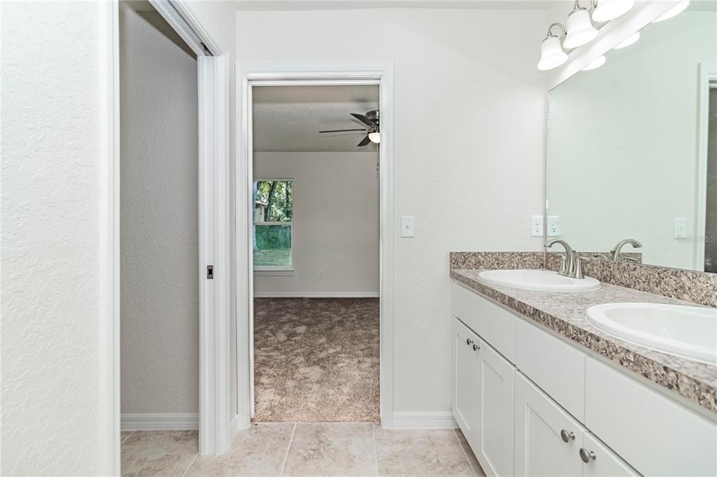 61 Larch Run Ocala, FL 34480 - Photo 19 of 26 a bathroom with a granite countertop sink and a mirror