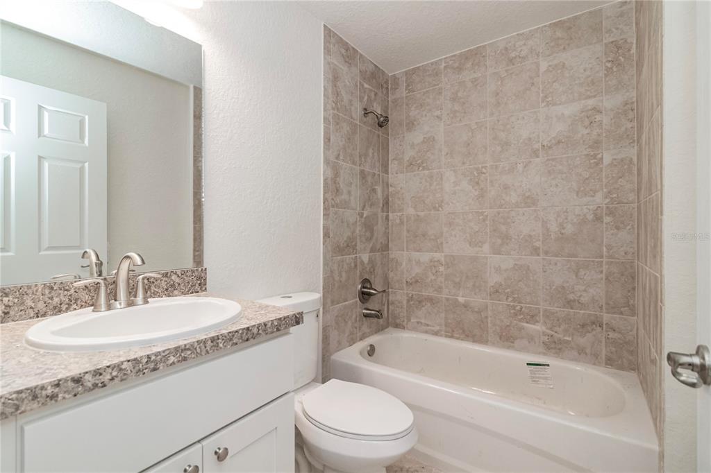 61 Larch Run Ocala, FL 34480 - Photo 23 of 26 a bathroom with a granite countertop sink a toilet and shower