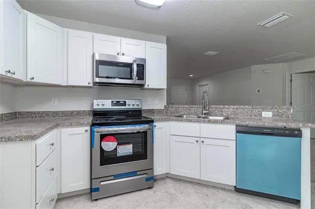 a kitchen with granite countertop a sink and a stove top oven