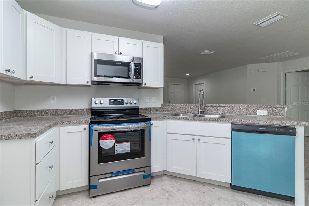 61 Larch Run Ocala, FL 34480 - Photo 9 of 26 a kitchen with granite countertop a sink and a stove top oven