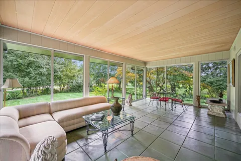 a living room with furniture and floor to ceiling windows