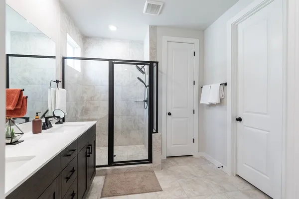 a bathroom with a double vanity sink mirror double and shower