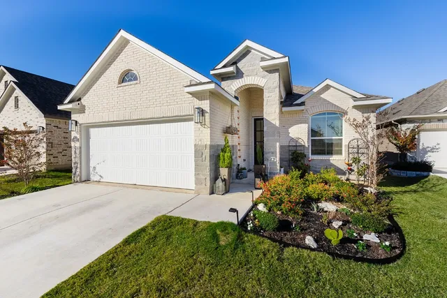 a kitchen with stainless steel appliances granite countertop a refrigerator a sink dishwasher a dining table and chairs with wooden floor