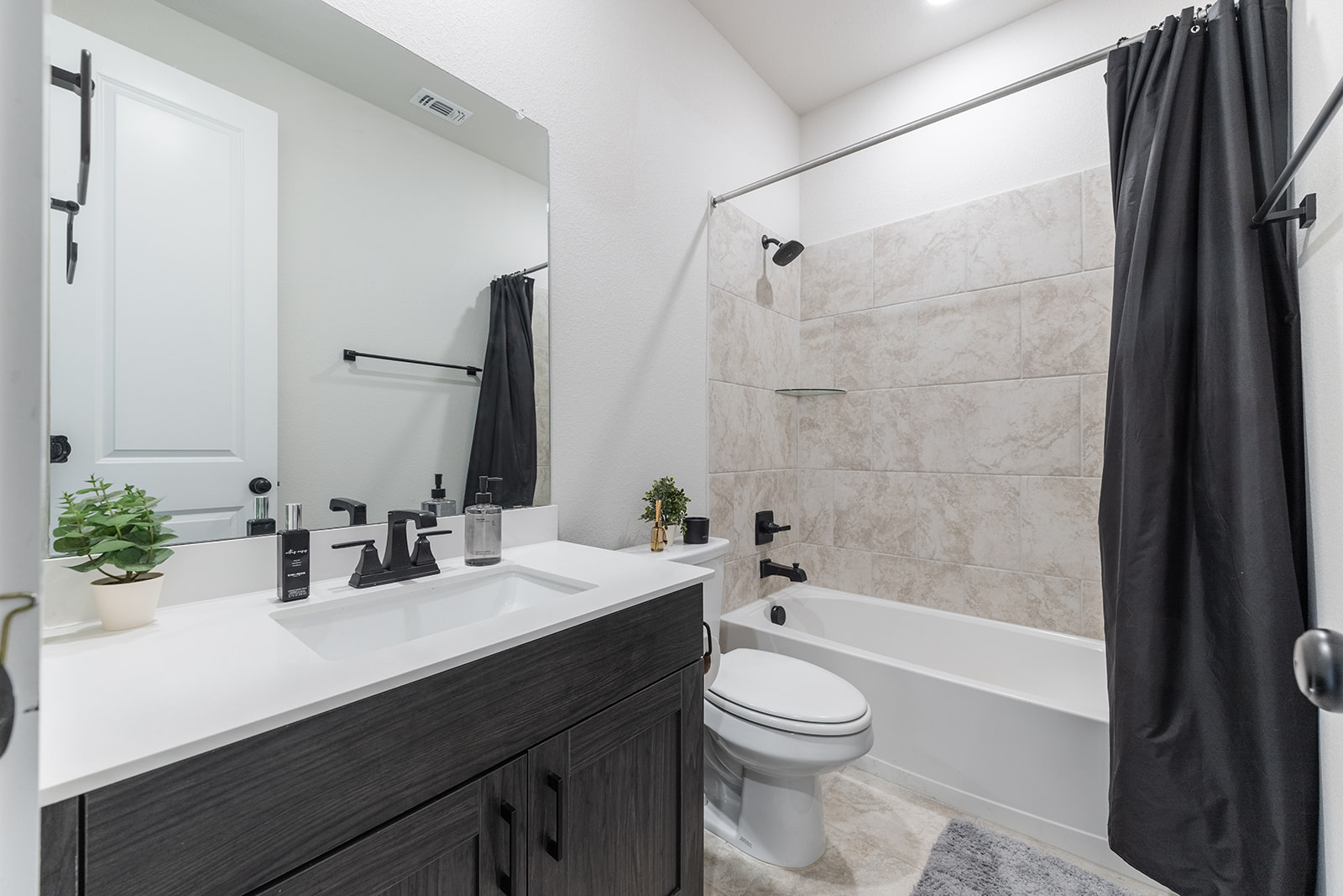 972 Leaning Oak Lane Georgetown, TX 78628 - Photo 20 of 33 a bathroom with a sink a toilet a mirror a bathtub and shower
