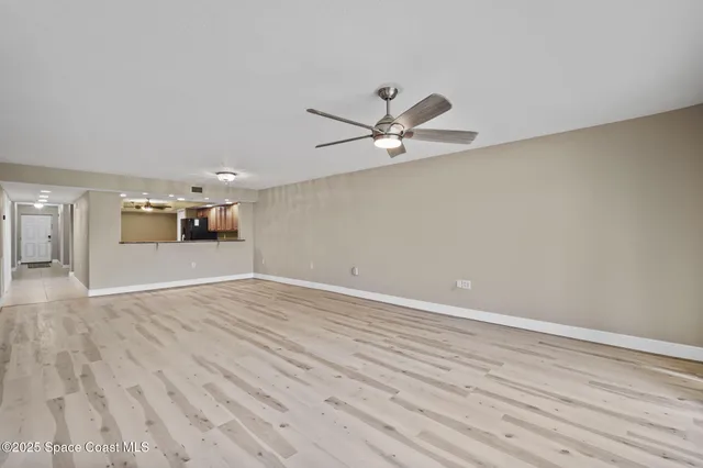 a view of a room with wooden floor and ceiling fan