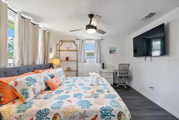 a bedroom with a bed window tv and couch