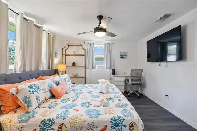 a bedroom with a bed window tv and couch