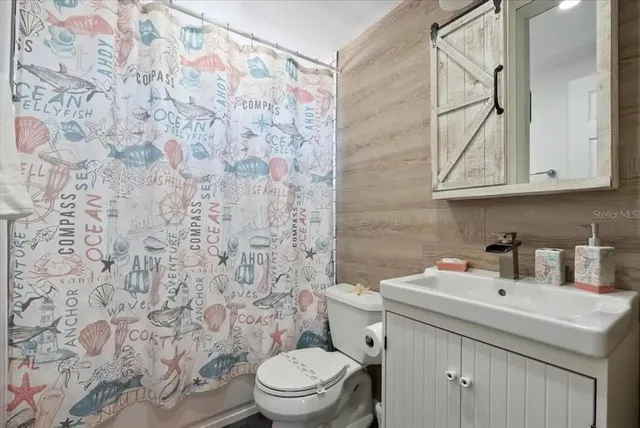 a bathroom with a sink toilet vanity and shower