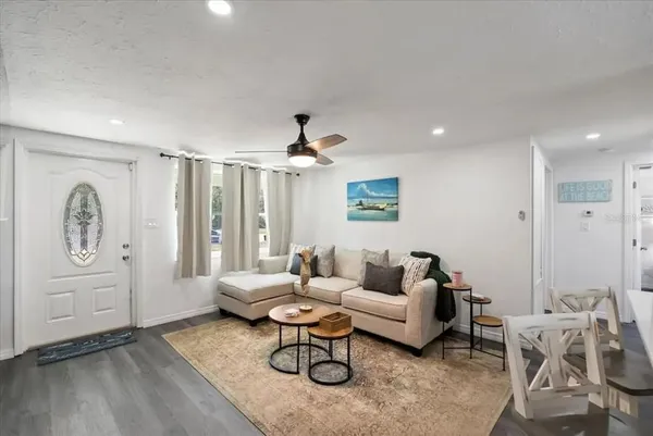 a living room with furniture a large window and a chandelier
