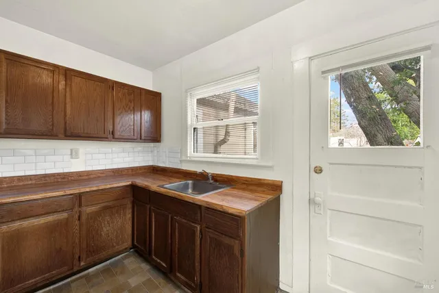 a kitchen with stainless steel appliances granite countertop wooden cabinets a sink and a window