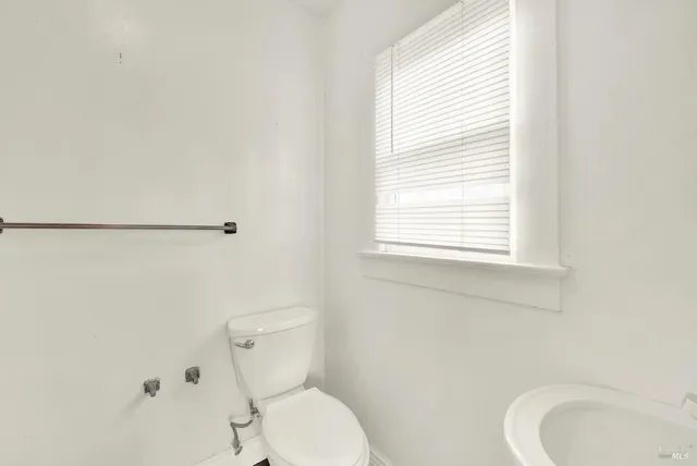 a white toilet sitting next to a bathroom sink