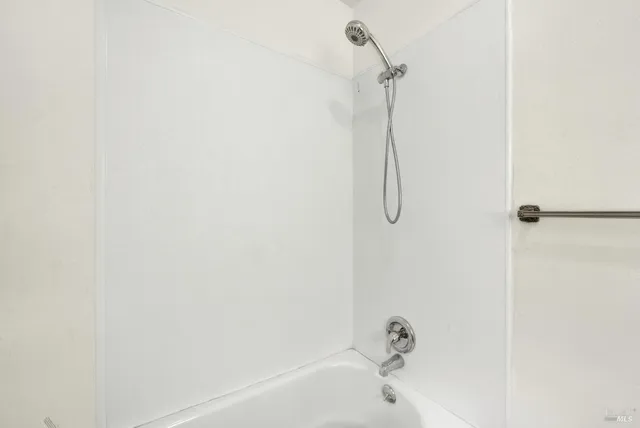 a bathroom with a bath tub with a shower