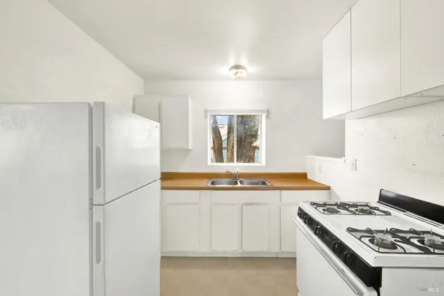 a kitchen with stainless steel appliances a stove a refrigerator and a sink
