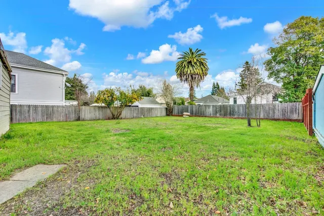 a view of a house with backyard and a tree