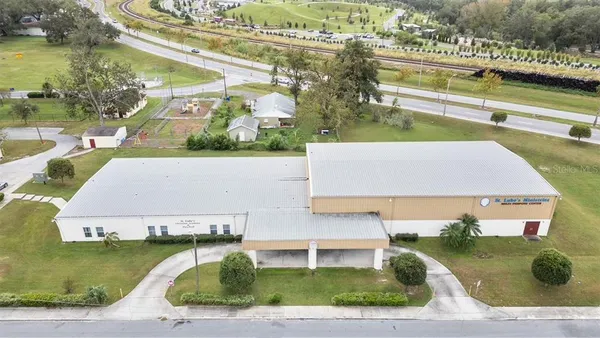 an aerial view of a house with a yard and lake view
