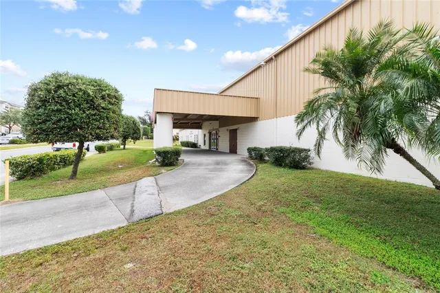 a swimming pool with a yard and palm trees