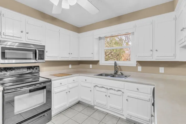 a kitchen with white cabinets and appliances