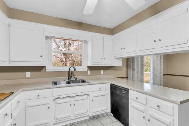a kitchen with white cabinets and white appliances