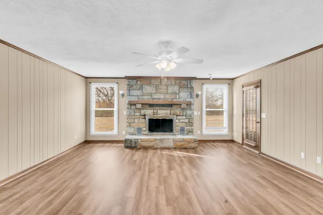 wooden floor fireplace and windows in an empty room