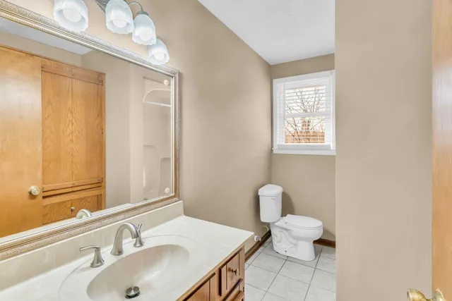 a bathroom with a sink vanity granite and toilet