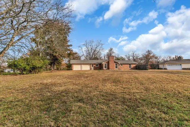 a view of outdoor space with green field and trees