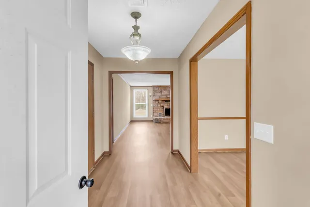 a view of a hallway with wooden floor and staircase