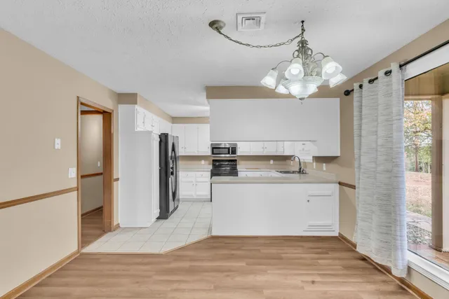 a view of a kitchen with a sink and refrigerator