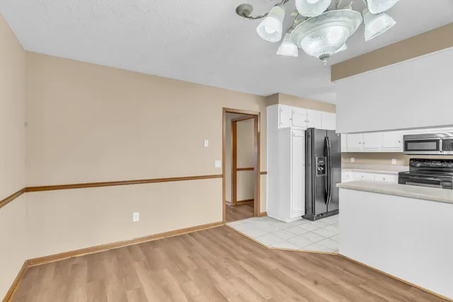 a kitchen with stainless steel appliances a refrigerator and a chandelier