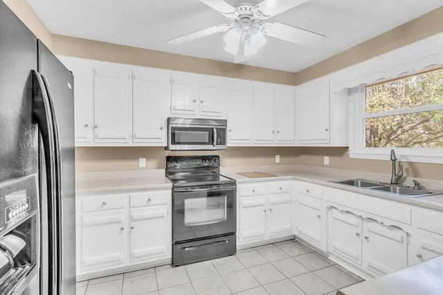 a kitchen with white cabinets and white appliances