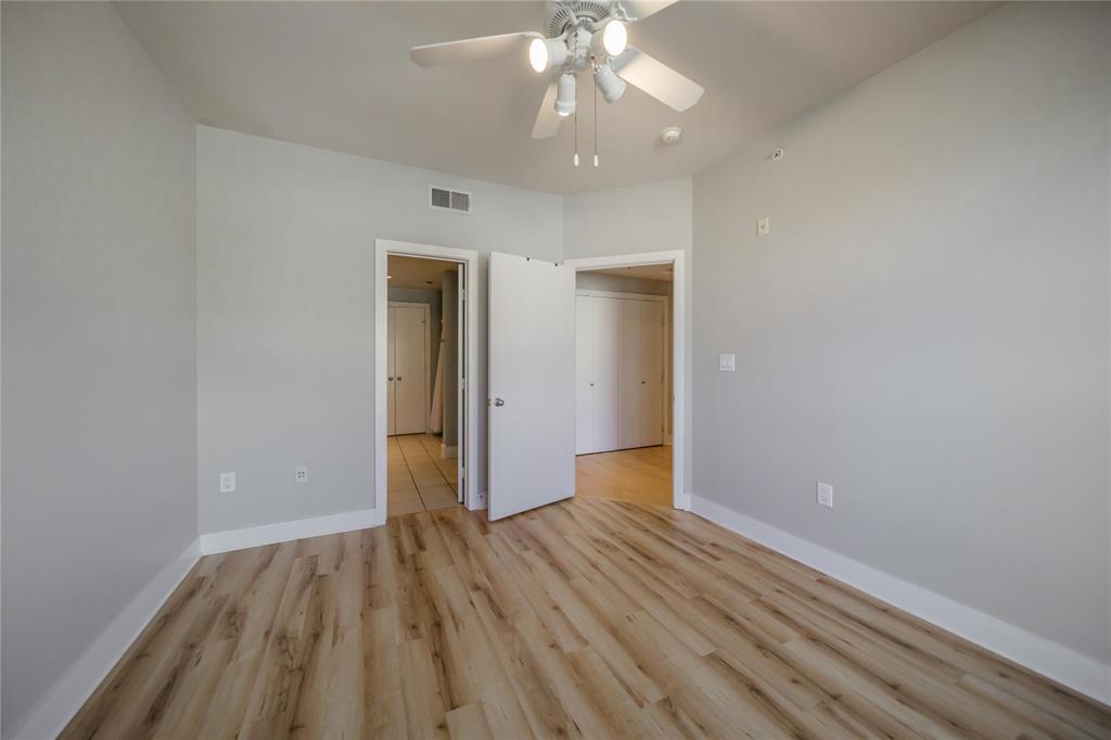 4414 Cedar Springs Road, Unit 214 Dallas, TX 75219 - Photo 17 of 29 Unfurnished bedroom featuring light wood-style floors and a ceiling fan