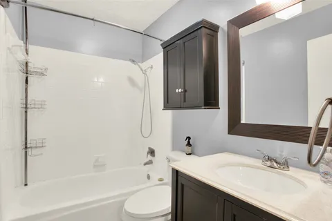 a bathroom with a granite countertop sink toilet and shower