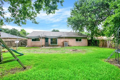 a front view of house with a garden and trees