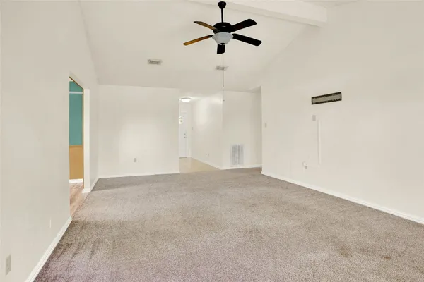 an empty room with a ceiling fan and a window