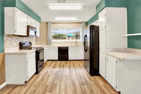a kitchen with a refrigerator stove top oven and sink