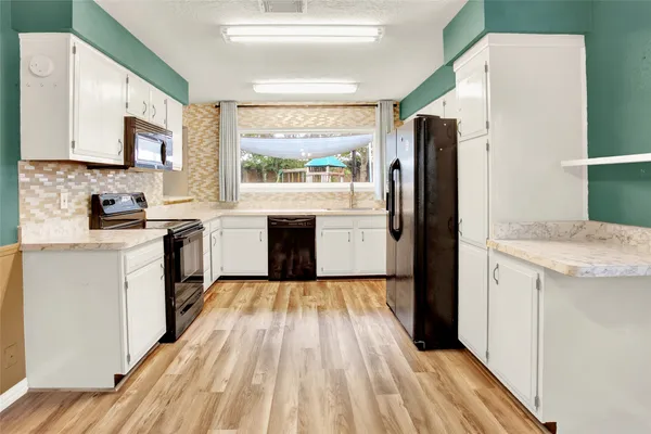 a kitchen with a refrigerator stove top oven and sink