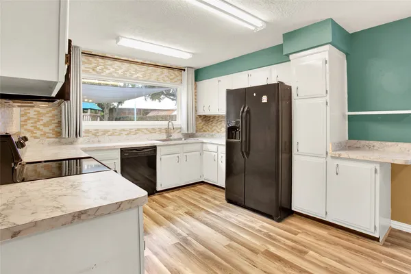 a kitchen with a refrigerator sink and cabinets