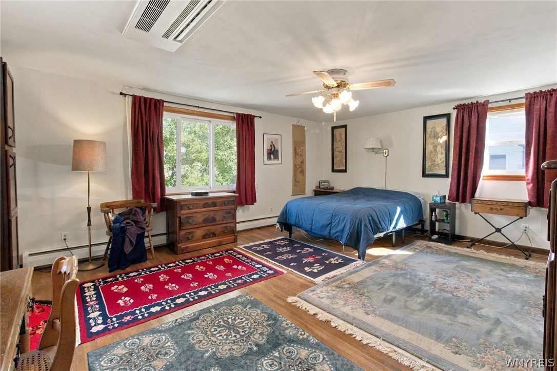 123 Ranch Trail West Amherst, NY 14221 - Photo 16 of 38 Rich wood flooring anchors this generous bedroom space filled with natural light.
