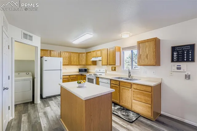 a view of a kitchen with refrigerator stove sink and cabinets