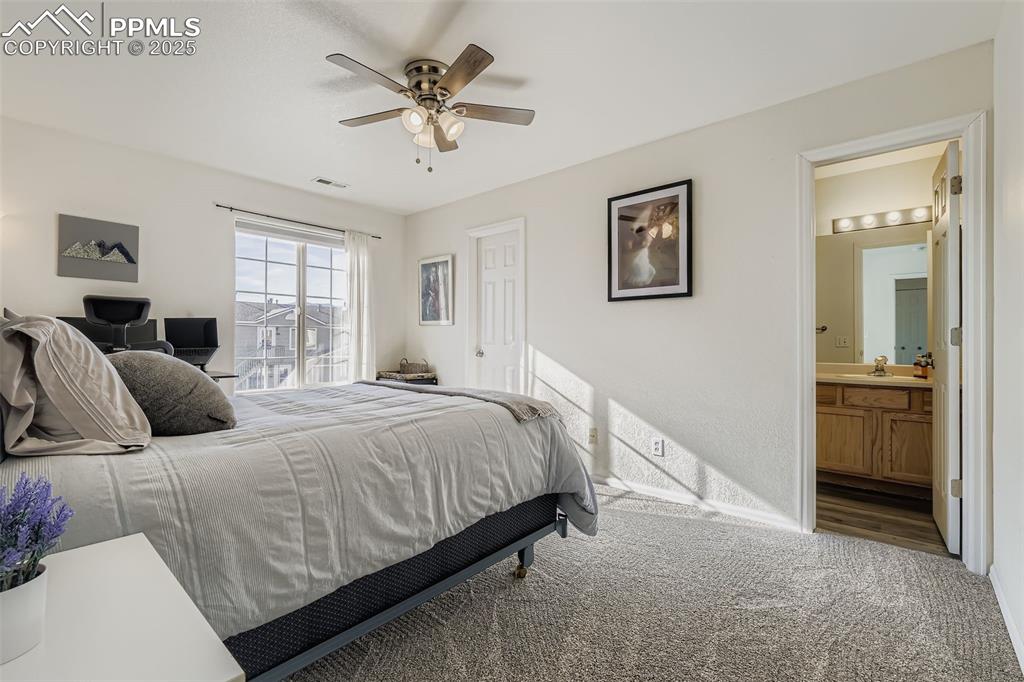 283 Ellers Grove Colorado Springs, CO 80916 - Photo 10 of 17 a bedroom with a bed and a chandelier